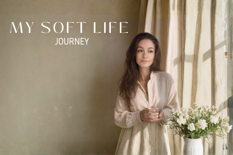 A young woman with long brown hair stands indoors near a softly lit window with beige curtains. She wears a cream-colored shirt and holds a clear glass of water. A vase of white flowers sits nearby. The scene conveys a peaceful, minimalist lifestyle. Text on the left reads “MY SOFT LIFE JOURNEY.”