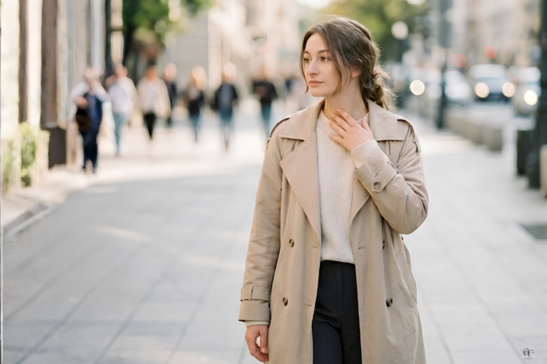 A woman walking through a busy city street with a hand near her neck, capturing the subtle physical tension and everyday stress that can contribute to anxiety.