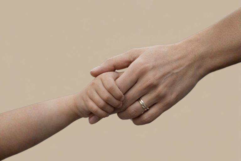Adult and child holding hands against a neutral background, symbolizing safety, reassurance, and parental support for a Child Bullied at School.
